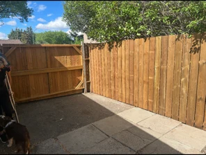 Finished cedar privacy fence and gate along a side yard with a paver walkway, Regina SK